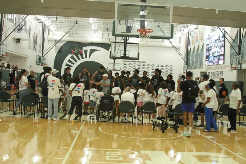 Magic of Literacy scholars posing with MSU basketball players at center court